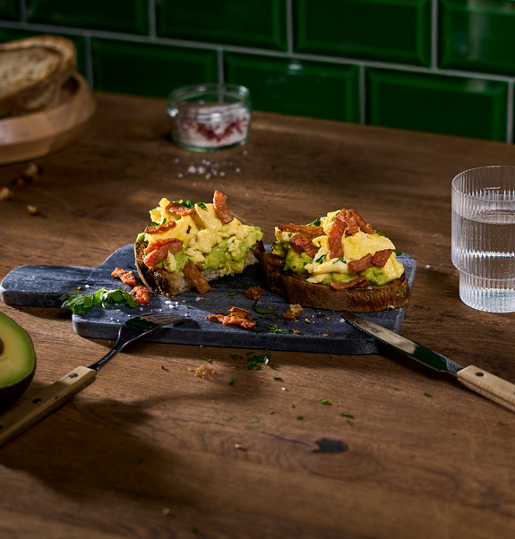 Frühstücks-Stulle mit veganen no Bacon Bites lecker angerichtet auf einem Holzbrett