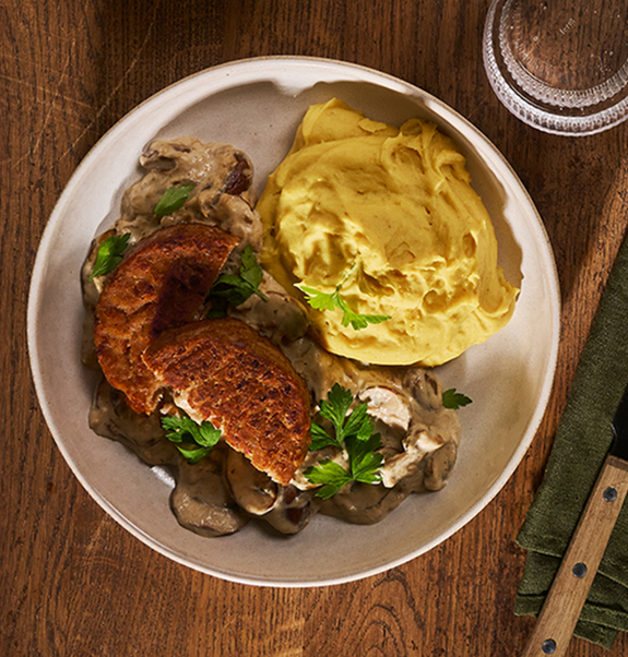 Veganen Klopse in Pilzrahmsoße mit Kartoffel-Kürbis-Püree. Mit veganem Mühlen Hack – damit wirst du alle Gäste beeindrucken. Probier’s mal aus!